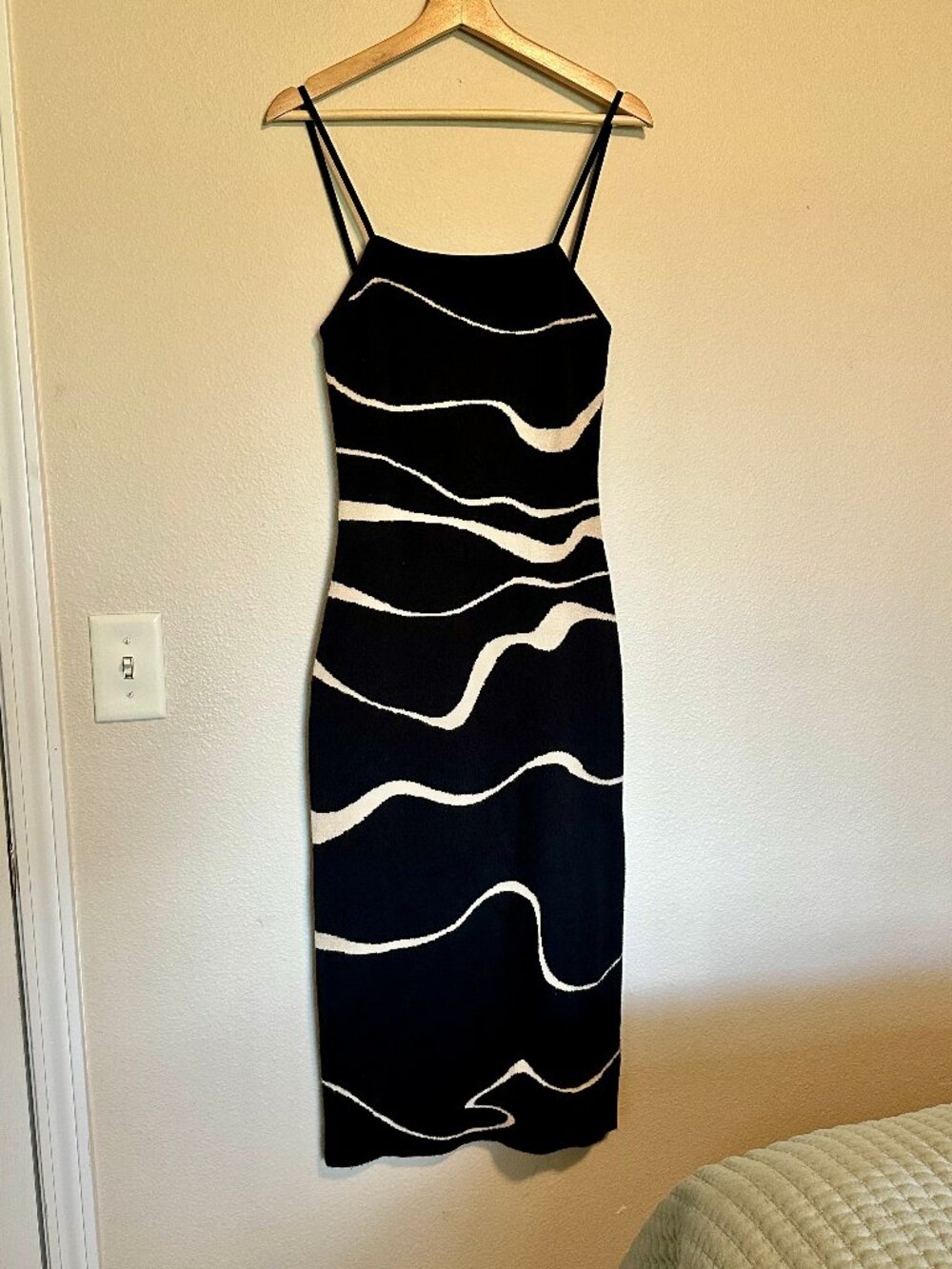 Black knit midi dress with an abstract wave pattern